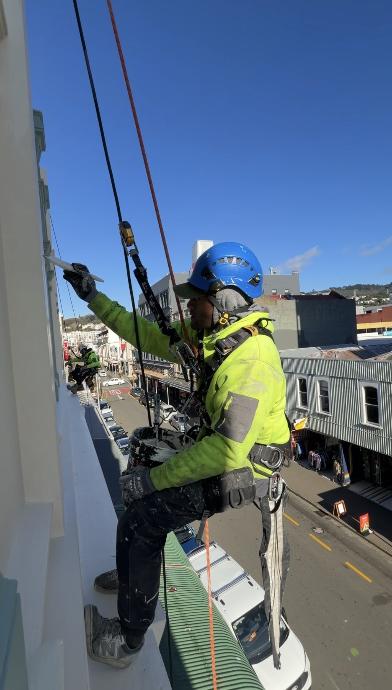 Painter applying fresh paint to a building exterior