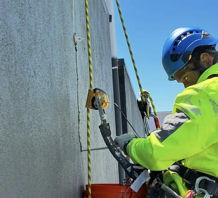 Rope access technician carrying out work on a concrete building facade