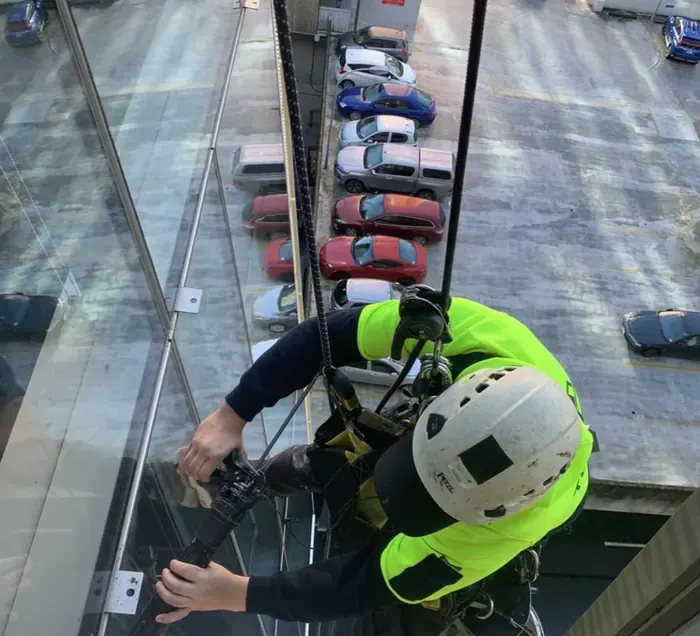 Rope access technician working beside a building facade